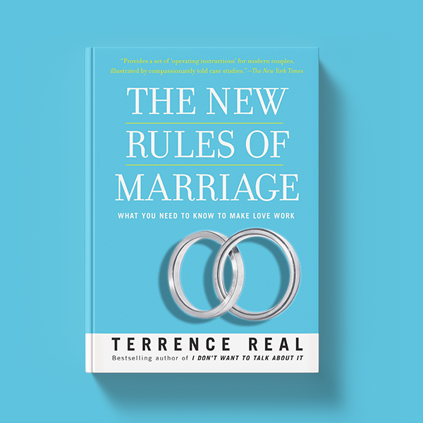 This is a demonstration of the physical book "The New Rules of Marriage": What You Need to Know to Make Love Work by Terry Real. It features a blue cover with two silver wedding rings intertwined.