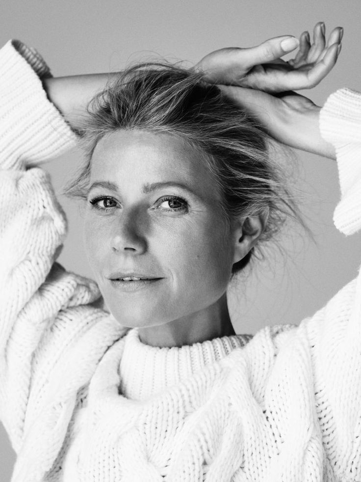 Gwyneth is looking directly at the camera, with a slight smile on her face and holding her hair up.